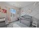 Charming Bedroom featuring a gray crib, decorative wall, and soft, neutral tones at 1114 Basalt Ridge Loop, Castle Rock, CO 80108