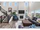 Bright living room featuring a fireplace, large windows, staircase, and soaring high ceilings at 1114 Basalt Ridge Loop, Castle Rock, CO 80108