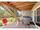 Cozy patio area with outdoor seating and a view of the landscaped backyard and overhead deck structure at 1114 Basalt Ridge Loop, Castle Rock, CO 80108