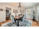 Elegant dining room offers a rustic table, modern lighting, and a view into the kitchen at 17509 E Kenyon Dr, Aurora, CO 80013