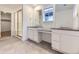 Modern bathroom with dual sinks, granite countertops, tiled floors, glass enclosed shower, and neutral paint at 7440 S Yank Ct, Littleton, CO 80127