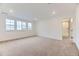 Bright main bedroom featuring large windows, neutral carpet flooring, and neutral paint throughout at 7440 S Yank Ct, Littleton, CO 80127
