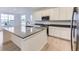 Modern kitchen with white cabinets, stainless steel appliances, an island with seating, and hard wood flooring at 7440 S Yank Ct, Littleton, CO 80127