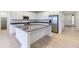 Modern kitchen with white cabinets, stainless steel appliances, an island with seating, and hardwood flooring at 7440 S Yank Ct, Littleton, CO 80127