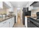 This kitchen features stainless steel appliances and matching white cabinets at 9837 E Peakview Ave # D05, Englewood, CO 80111