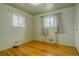 This light-filled bedroom with wood floors features two windows and classic trim at 11241 Ogden Dr, Northglenn, CO 80233