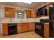 Functional kitchen featuring wooden cabinets and black appliances offers practicality and style at 11241 Ogden Dr, Northglenn, CO 80233