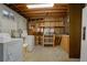 Unfinished laundry room with washer, dryer, and wood shelving at 11241 Ogden Dr, Northglenn, CO 80233