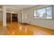 Spacious living room with gleaming hardwood floors, a front door, and open access to the adjacent dining area at 11241 Ogden Dr, Northglenn, CO 80233