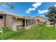 Exterior view of sunroom addition with bench and landscaped yard at 11241 Ogden Dr, Northglenn, CO 80233