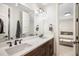 Double vanity bathroom featuring a quartz countertop, shaker cabinets, black hardware, and modern lighting at 2821 E Cedar Ave # 2, Denver, CO 80209