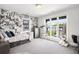 A trendy bedroom features an accent wall, cargo bed frame, gray carpet, and oversized windows at 2821 E Cedar Ave # 2, Denver, CO 80209