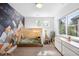 A starry themed bedroom features a play tent, rocket wallpaper, and soft, natural light from large windows at 2821 E Cedar Ave # 2, Denver, CO 80209