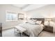 A serene bedroom is styled with neutral colors, soft textures, and natural light from a window view at 2821 E Cedar Ave # 2, Denver, CO 80209