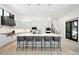Beautiful white kitchen showcasing a spacious island with seating and modern lighting fixtures at 2821 E Cedar Ave # 2, Denver, CO 80209