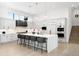 Modern white kitchen featuring a large island, pendant lighting, and stainless steel appliances at 2821 E Cedar Ave # 2, Denver, CO 80209