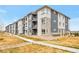 Modern apartment complex with stone accents, gray siding, and well-maintained landscaping at 16841 Askins Loop # 101, Parker, CO 80134