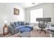 Bright office/bedroom with a blue sofa, ottoman, desk, and natural light at 16841 Askins Loop # 101, Parker, CO 80134