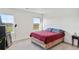 Bright bedroom with carpet flooring, a red bed, and natural lighting from two windows at 4125 Marble Dr, Longmont, CO 80504