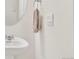 Modern powder room with a pedestal sink, round mirror, and brushed nickel towel ring at 4125 Marble Dr, Longmont, CO 80504