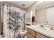 Bright bathroom featuring a tropical themed shower curtain, vanity, and built in shelving unit at 481 S Kalispell Way # 205, Aurora, CO 80017