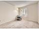 Bright bedroom with plush carpeting and a decorative chair by the window at 481 S Kalispell Way # 205, Aurora, CO 80017