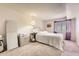 Bright bedroom with carpet, white walls, and a cozy bed near the window at 481 S Kalispell Way # 205, Aurora, CO 80017