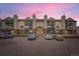 Condo building with private balconies and brick accents, set against a vibrant sunset sky at 481 S Kalispell Way # 205, Aurora, CO 80017