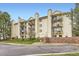 Exterior view of a tan three story apartment building with black wrought iron balconies at 481 S Kalispell Way # 205, Aurora, CO 80017