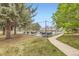 Community grilling area surrounded by mature trees, sidewalk, and grass for resident's enjoyment at 481 S Kalispell Way # 205, Aurora, CO 80017