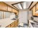 Functional kitchen featuring wood cabinets, essential appliances, and bright overhead lighting at 481 S Kalispell Way # 205, Aurora, CO 80017