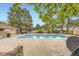 Community pool with blue water surrounded by a concrete deck, trees, and a fence at 481 S Kalispell Way # 205, Aurora, CO 80017