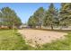 Community sand volleyball court bordered by mature pine trees on a sunny day at 481 S Kalispell Way # 205, Aurora, CO 80017
