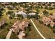 Stunning aerial view of a home with mature landscaping and a community pond at 5069 Castle Pines S Dr, Castle Rock, CO 80108