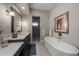 Bathroom showcasing a soaking tub, stylish fixtures, and sleek dark wood cabinets at 5069 Castle Pines S Dr, Castle Rock, CO 80108