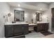 Bathroom featuring double sinks, quartz countertops, and dark wood cabinetry at 5069 Castle Pines S Dr, Castle Rock, CO 80108