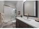 Bathroom featuring a shower over tub, vanity with storage, and a modern mirror at 5069 Castle Pines S Dr, Castle Rock, CO 80108