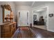 Inviting entryway featuring dark wood floors, a stylish mirror, and natural light from the sidelights around the front door at 5069 Castle Pines S Dr, Castle Rock, CO 80108