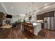 Open-concept kitchen with stainless steel appliances, a large island with seating, and dark wood flooring at 5069 Castle Pines S Dr, Castle Rock, CO 80108