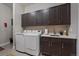 Well-organized laundry room with ample cabinet space, modern appliances, and a utility sink at 5069 Castle Pines S Dr, Castle Rock, CO 80108