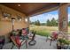 Relaxing covered patio with seating, featuring a stone column and open backyard view at 5069 Castle Pines S Dr, Castle Rock, CO 80108