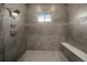 Luxurious shower with stylish gray tiles, a convenient bench, and a rainfall showerhead at 5069 Castle Pines S Dr, Castle Rock, CO 80108