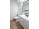 Modern half bathroom featuring updated vanity, mirror, and wood-look flooring at 10330 E Jewell Ave # 67, Aurora, CO 80247