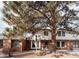 Charming townhome featuring a brick facade, white siding, and mature trees in a well-maintained community at 10330 E Jewell Ave # 67, Aurora, CO 80247