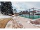 View of the community tennis court featuring a green court, black fencing, and well maintained landscaping at 10330 E Jewell Ave # 67, Aurora, CO 80247