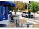 Sidewalk cafe with blue awnings and several outdoor tables and chairs at 1141 Adams St, Denver, CO 80206