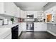 Well-lit kitchen with white cabinets, marble countertops, and black stainless steel dishwasher at 1141 Adams St, Denver, CO 80206