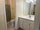 Neutral bathroom with a single sink vanity, shower with glass doors, and tiled flooring at 7906 W Walker Dr, Littleton, CO 80123