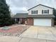 Charming two-story home featuring a brick facade, a two-car garage, and a beautifully landscaped front yard at 7906 W Walker Dr, Littleton, CO 80123