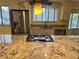 Gourmet kitchen featuring a center island with cooktop, a stainless steel refrigerator, and a view from the window at 7906 W Walker Dr, Littleton, CO 80123